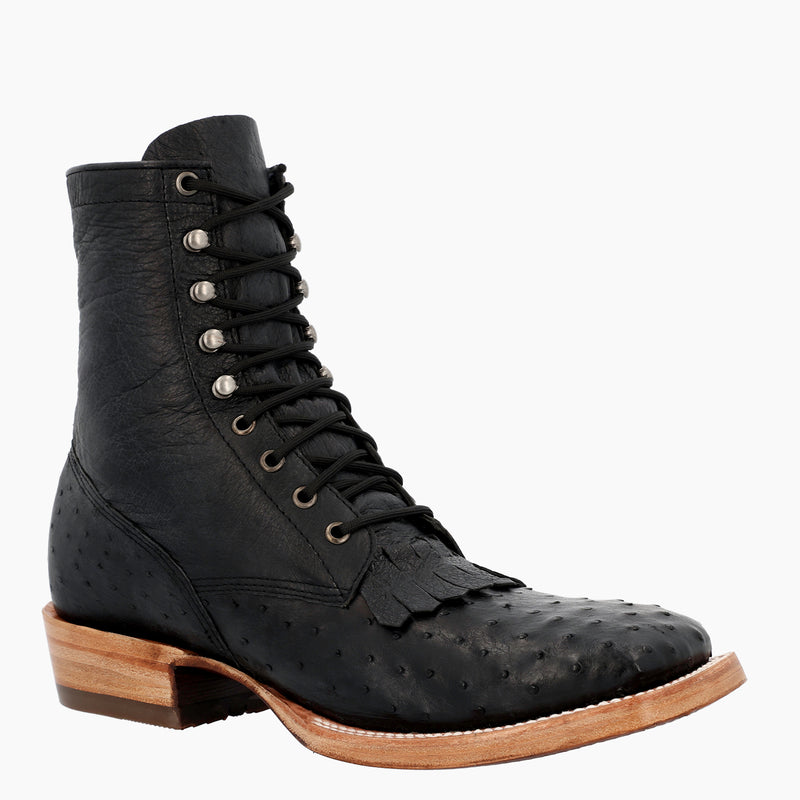 A black leather lace-up ankle boot with an ostrich-embossed texture on the toe, silver metal eyelets, and a light brown stacked wood-look heel, shown against a plain white background.
