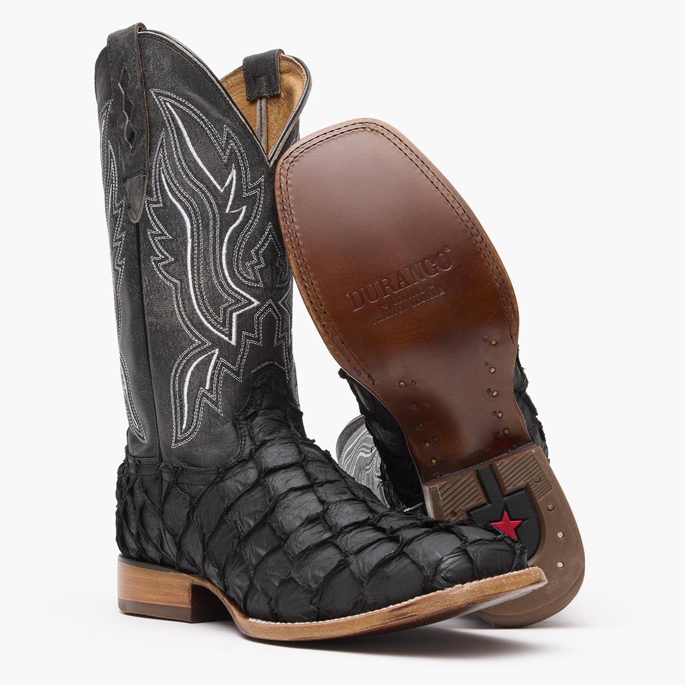 Leather outsole view of a pair of Durango black square toe Pirarucu fish western boots