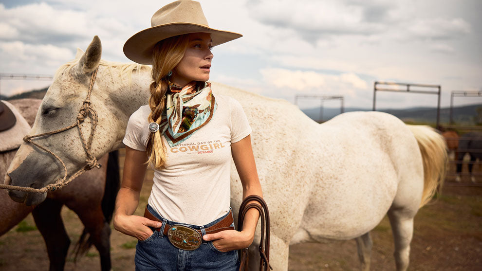 Cowgirl wearing National Day of the Cowgirl merch on the ranch