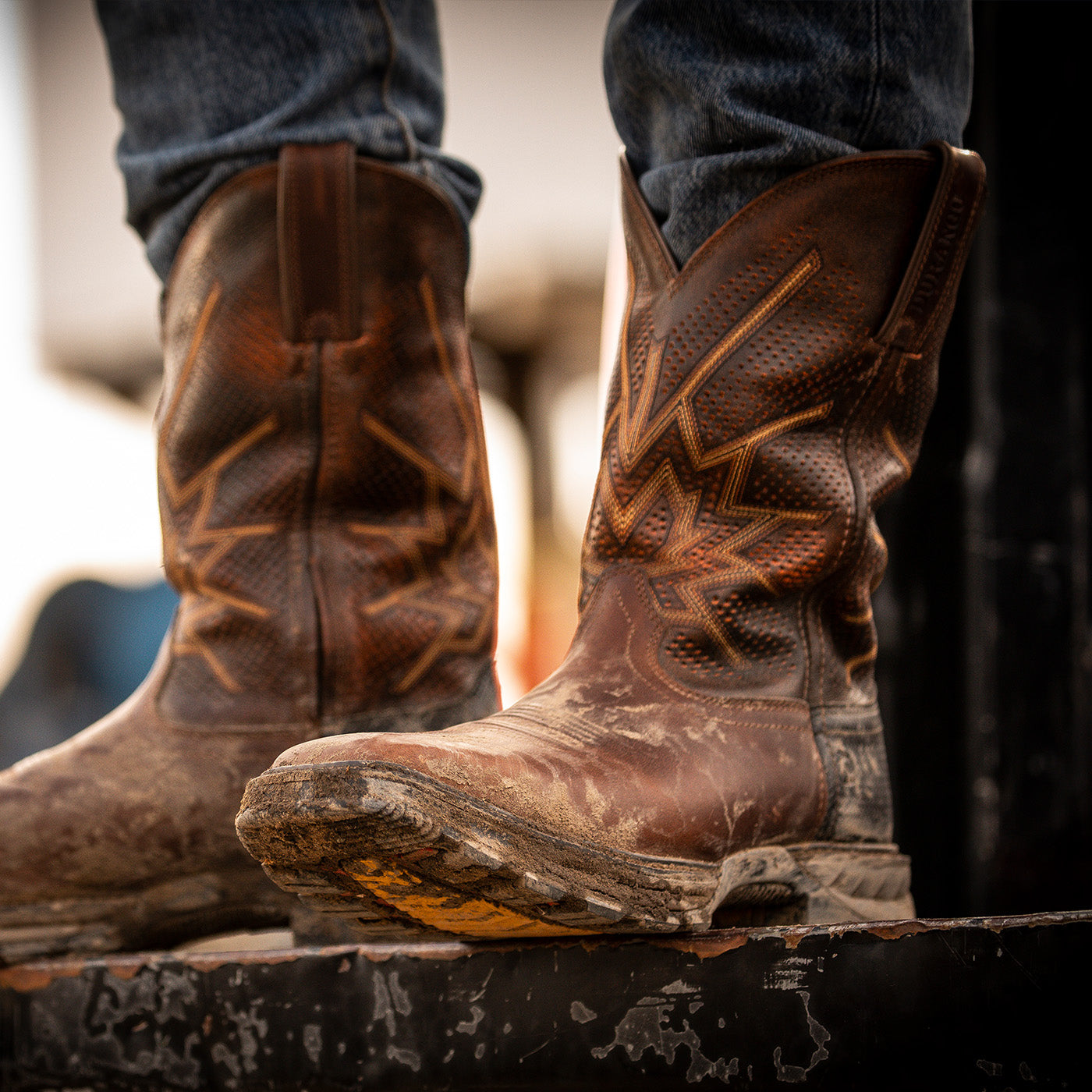 Brown work boots with visible wear on a blurred background