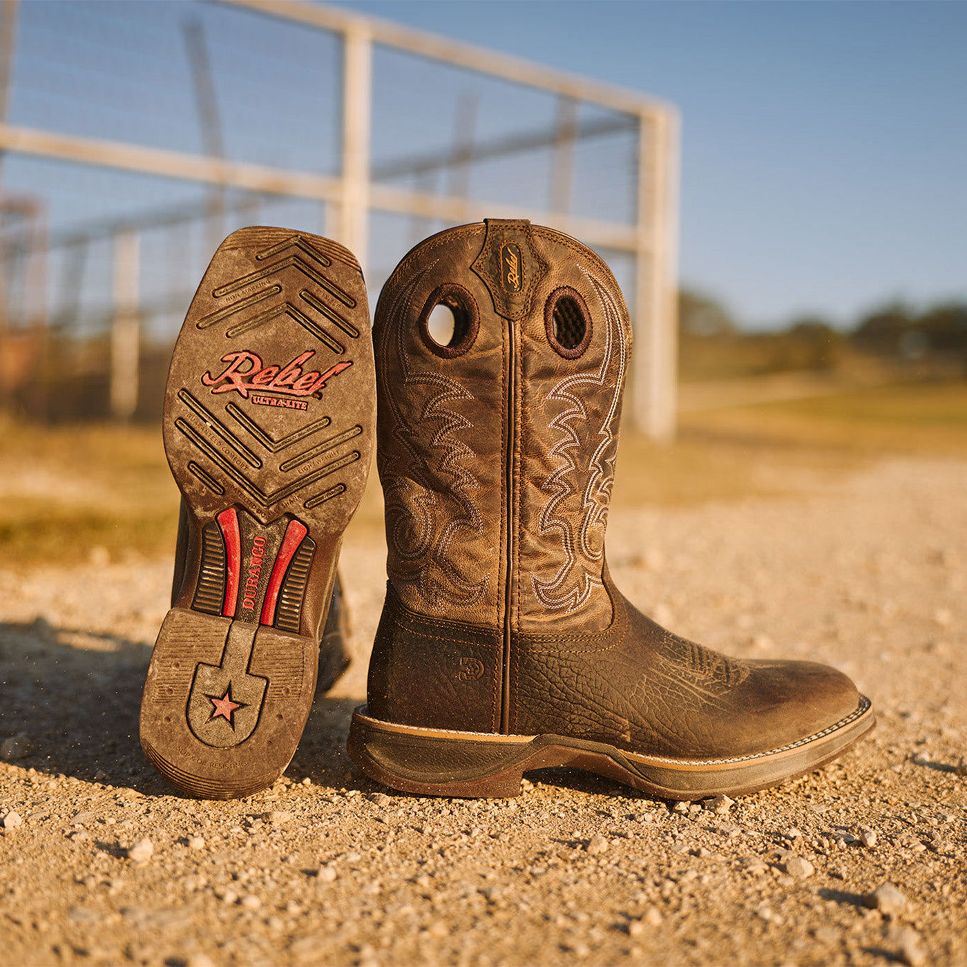 Brown Durango Rebel Ultra Lite western boots with outsole propped on a dirt road in Texas.