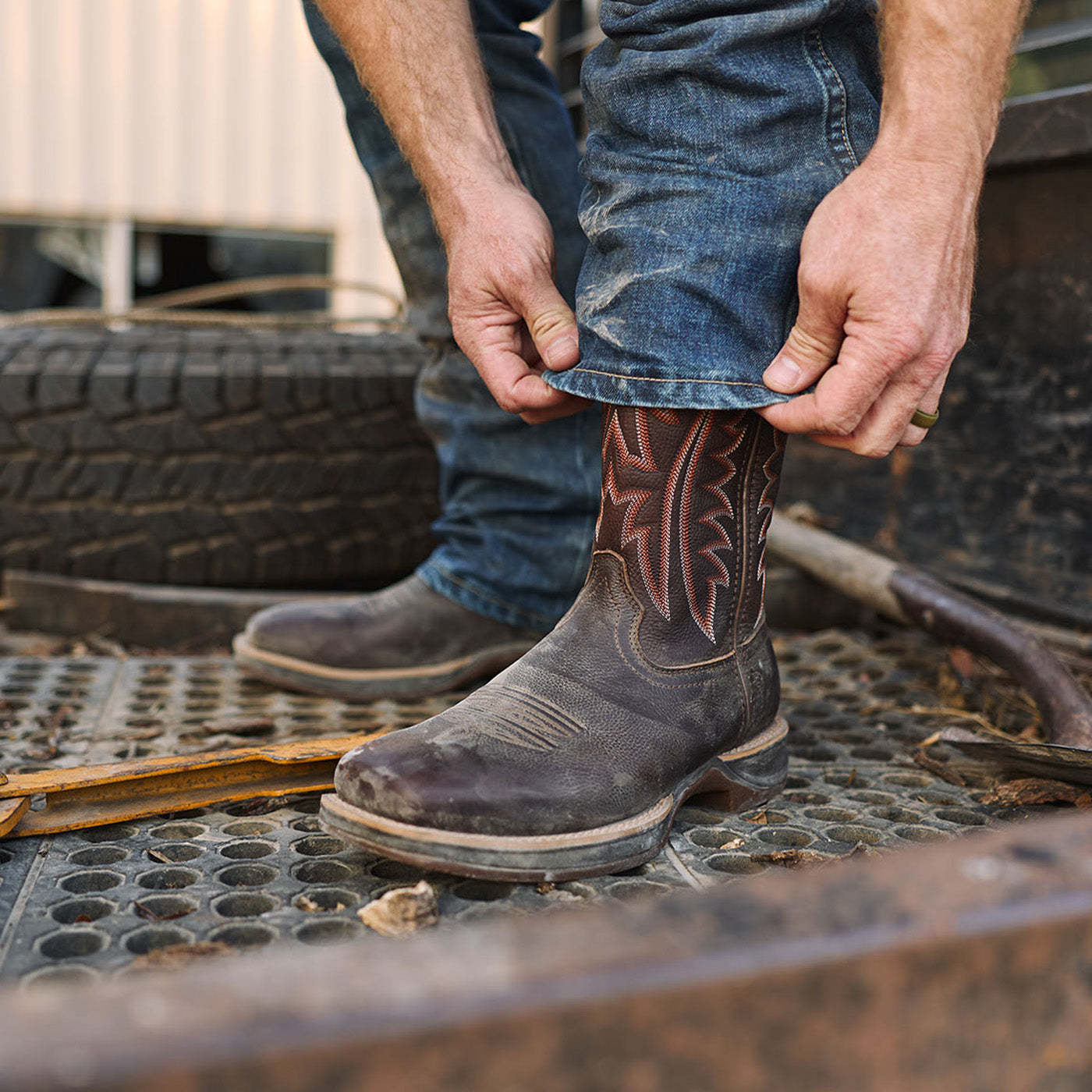 Person wearing a Rebel Ultra-Lite brown cowboy boot with intricate design on a metal truck bed.