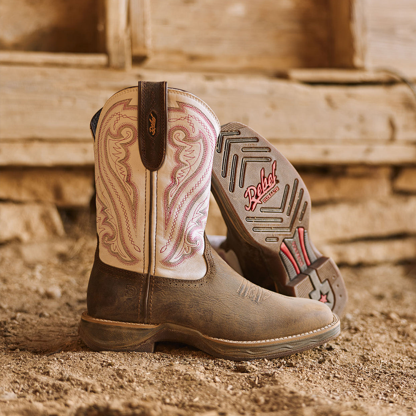 Brown and white Rebel Ultra-Lite womens boots with detailed design in a horse stall.