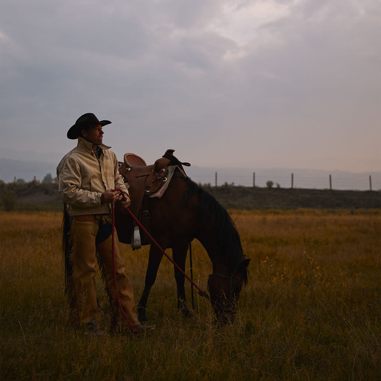 Cowboy wearing Durango Boots standing beside his horse at Diamond Cross Ranch in Wyoming.