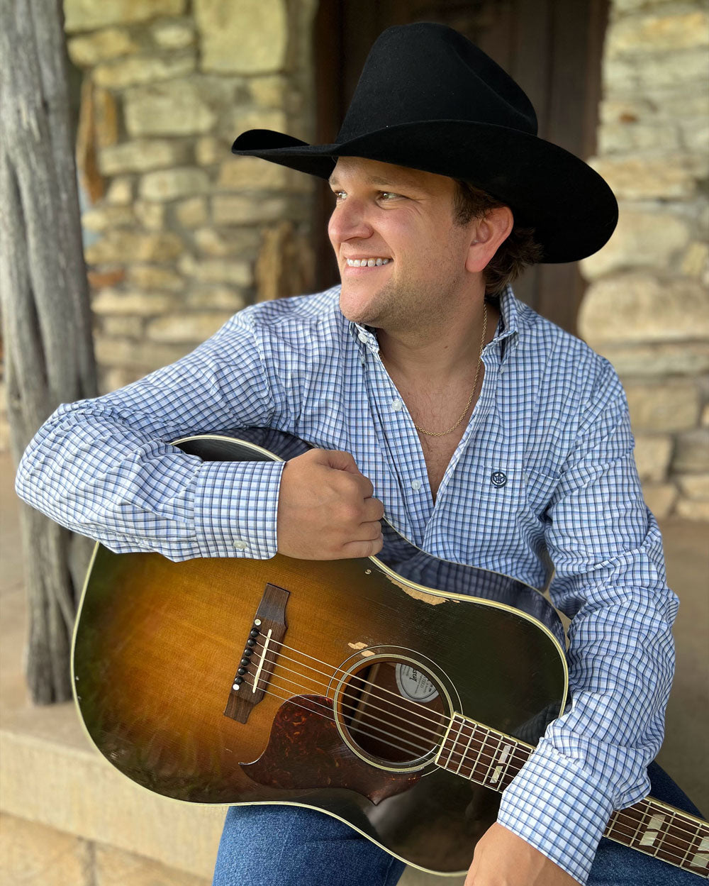David Adam Byrnes sitting with his guitar in hand.