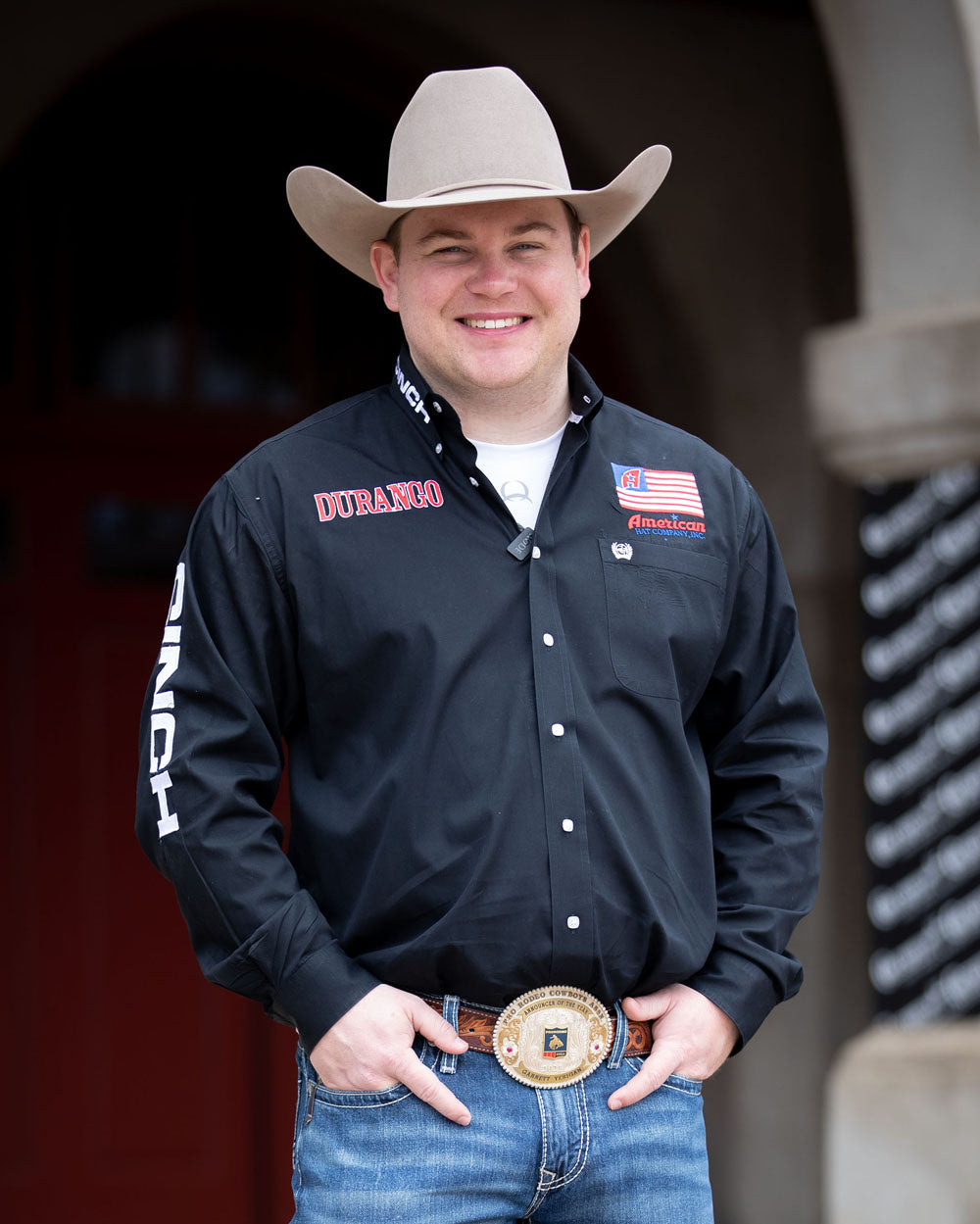 Team Durango Rodeo Announcer, Garrett Yerigan posing in front of a building.